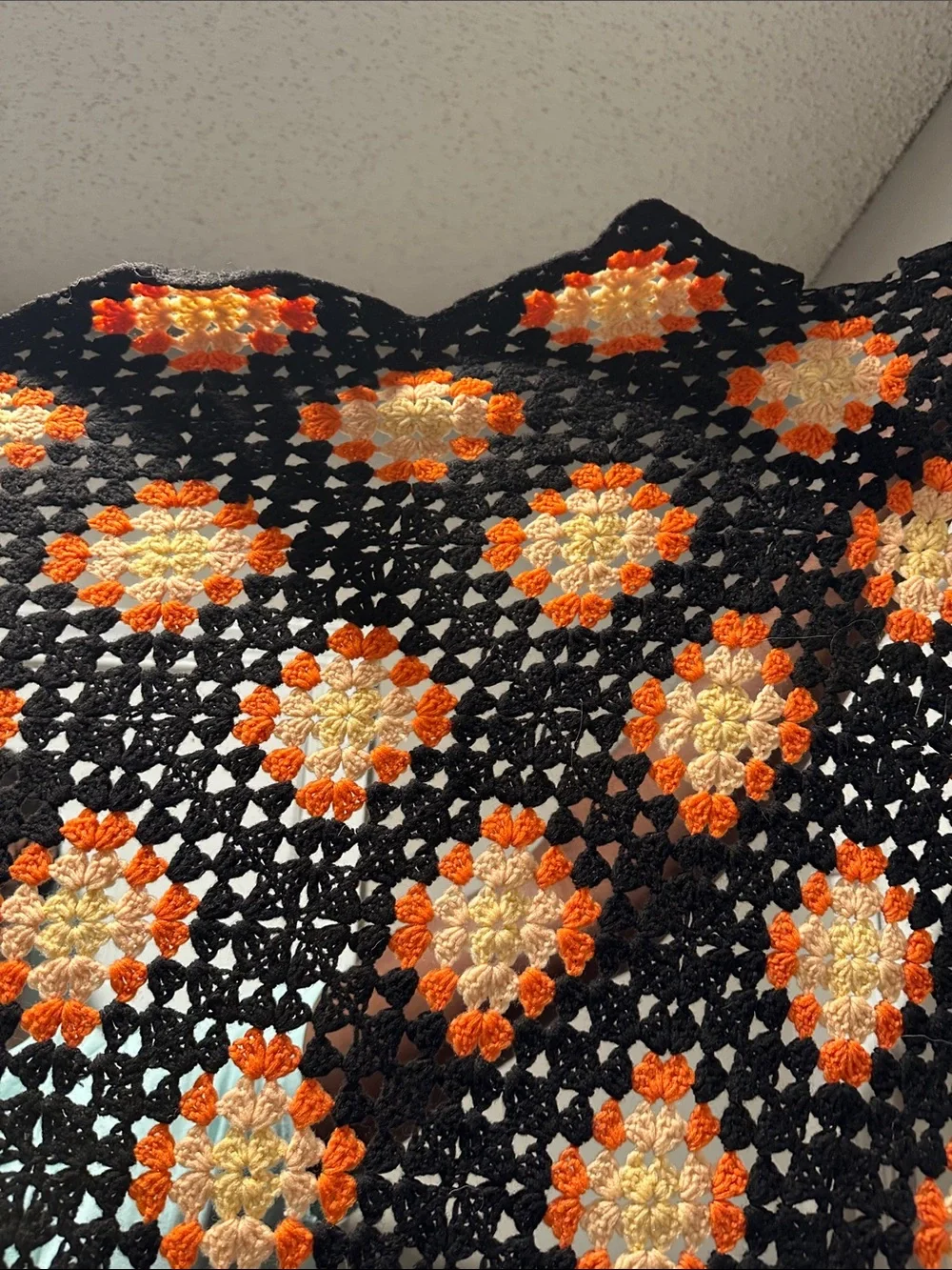 Granny Square black with orange crochet blanket with zig zag hem